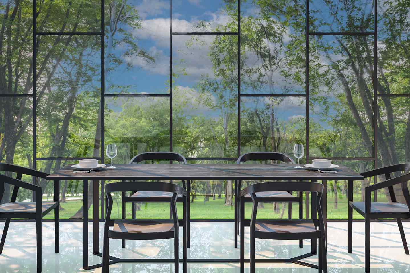 The image shows a view of lush green trees through a modern multi-pane window with black metal frames, creating a geometric pattern. Sunlight filters through the leaves, giving a bright and serene outdoor scene.